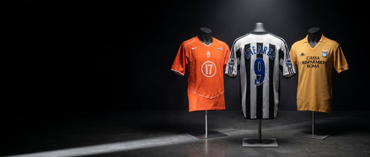 Three vintage football shirts on mannequin torsos under spotlights